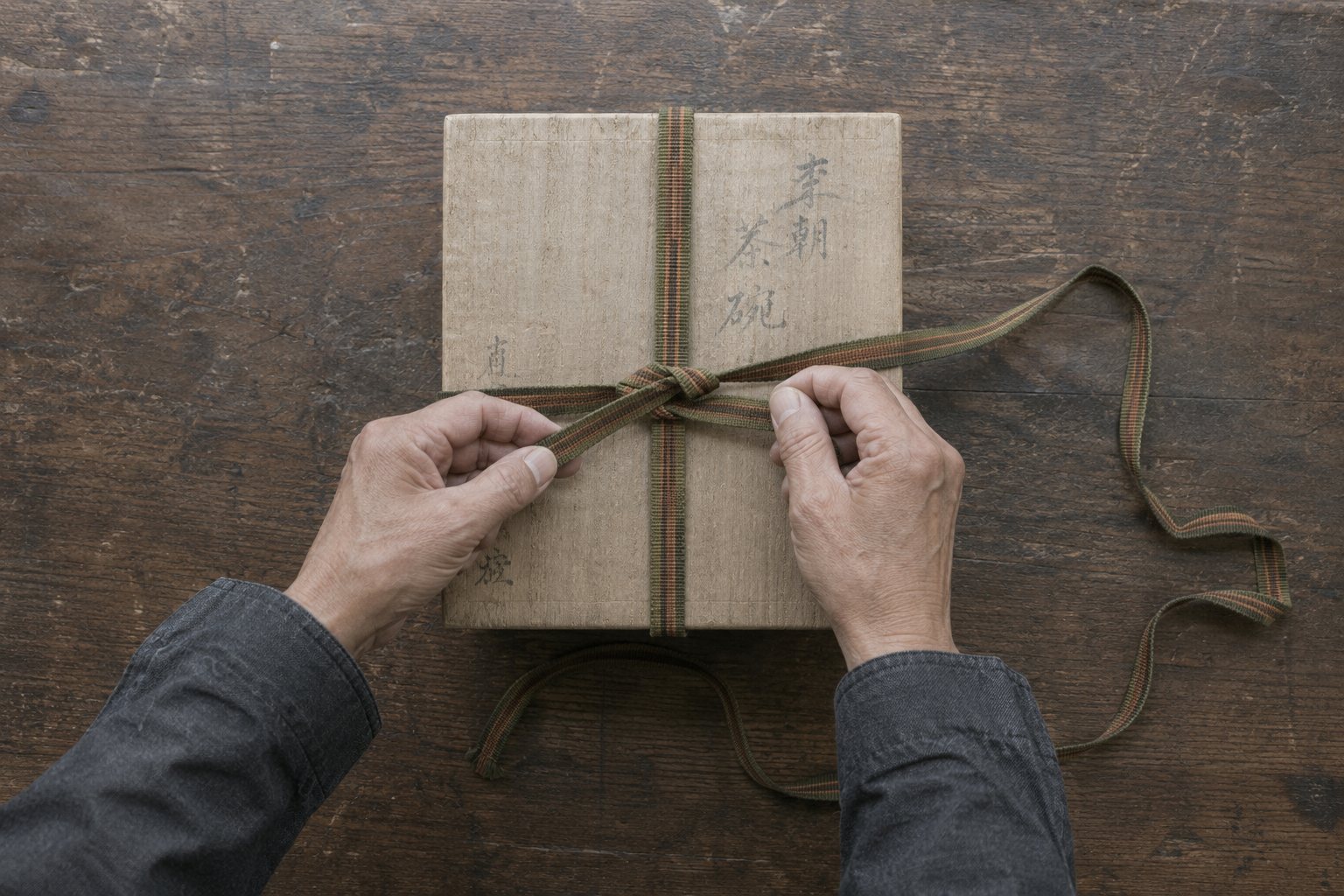 桐箱に真田紐を結ぶ手